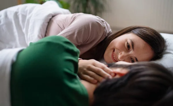 Young couple in love lying on bed indoors at home. — Stock Photo, Image