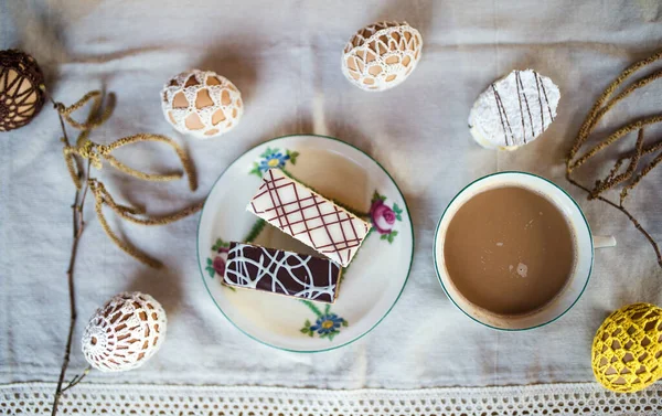 Top kilátás finom torta desszertek és kávé az asztalon, húsvéti dekorációk. — Stock Fotó