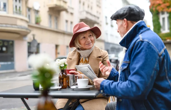 Oudere mensen zitten in outdoor cafe in de stad, praten. — Stockfoto