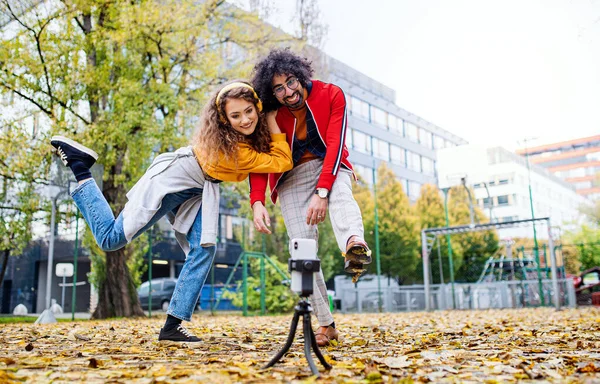 Молода пара зі смартфоном робить відео для соціальних медіа на відкритому повітрі в парку . — стокове фото