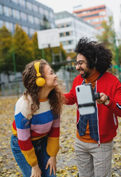 Jeune couple avec smartphone faire de la vidéo pour les médias sociaux en plein air dans le parc. — Photo