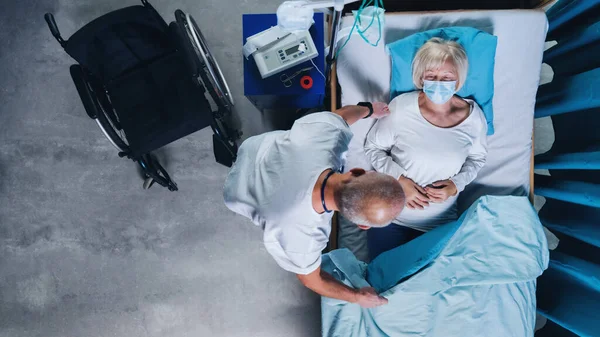 Ovanifrån av läkare att sätta covid-19 patient i sängen på sjukhus, coronavirus koncept. — Stockfoto