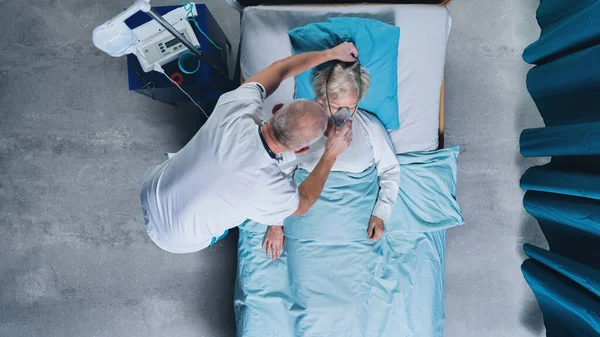 Visão superior do médico e paciente covid-19 com máscara de oxigênio na cama no hospital, conceito de coronavírus. — Fotografia de Stock