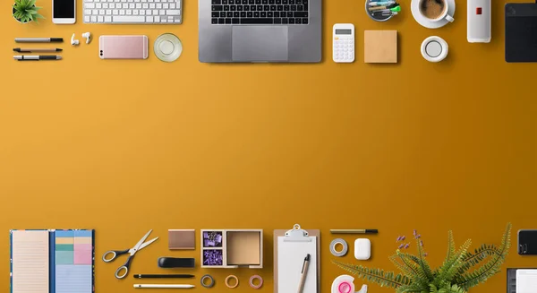 Flat lay vista superior escritório mesa de trabalho espaço com laptop e suprimentos no fundo laranja. — Fotografia de Stock