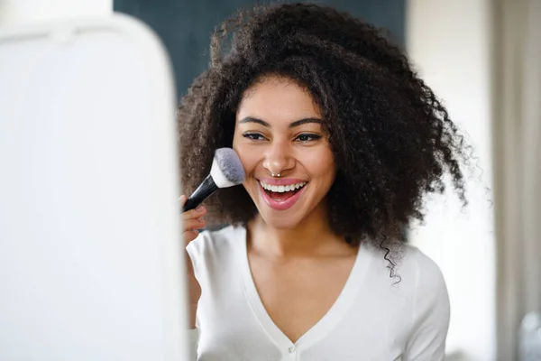 Retrato de close-up de mulher jovem com escova em casa, aplicando maquiagem. — Fotografia de Stock