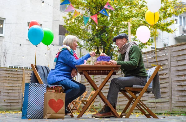 Szczęśliwa para seniorów z winem w kawiarni na świeżym powietrzu w mieście, świętowanie urodzin. — Zdjęcie stockowe