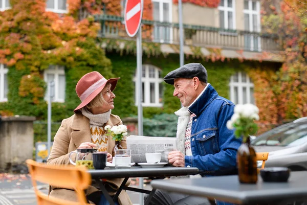 Personnes âgées assis dans un café extérieur en ville, parler. — Photo