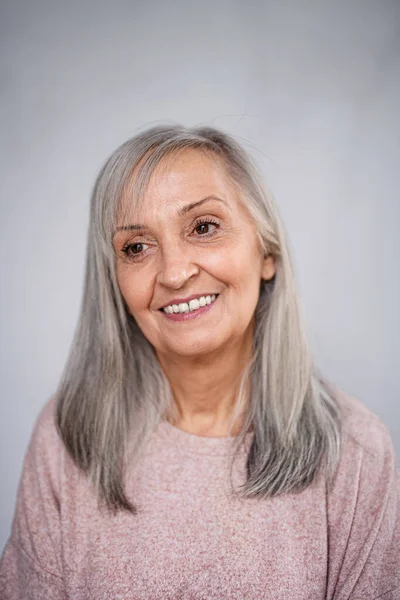 Visão frontal retrato de mulher sênior feliz de pé dentro de casa. — Fotografia de Stock