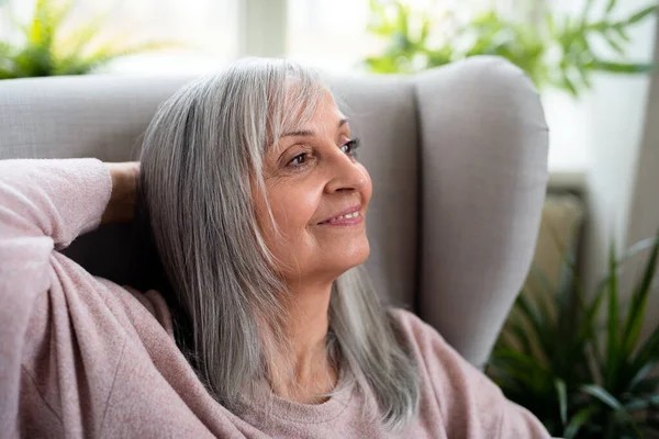 Портрет счастливой пожилой женщины, сидящей дома. — стоковое фото