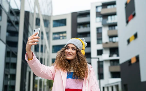 路上で屋外ソーシャルメディアのためのビデオを作るスマートフォンを持つ若い女性. — ストック写真