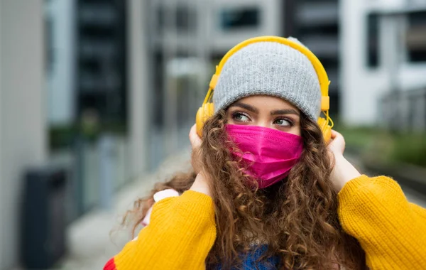 Jovem com máscara facial ao ar livre na rua, conceito coronavírus. — Fotografia de Stock