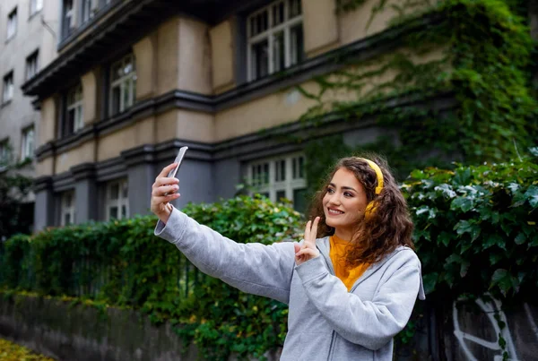 路上でスマートフォンを屋外に持つ若い女性,ソーシャルメディアのコンセプトのためのビデオ. — ストック写真