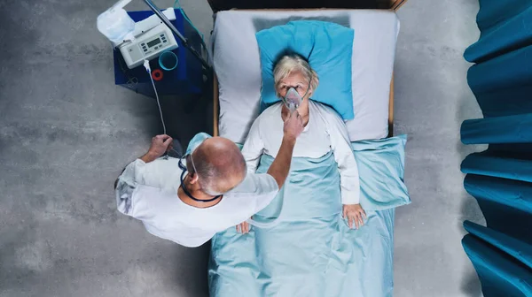 Draufsicht auf Arzt und Covid-19-Patient mit Sauerstoffmaske im Krankenhausbett, Coronavirus-Konzept. — Stockfoto