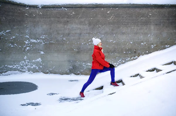 Активная пожилая женщина на открытом воздухе в снежную зиму, делая упражнения. — стоковое фото