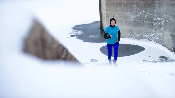 Aktivní starší žena běží venku v zimě, dělá cvičení. — Stock fotografie