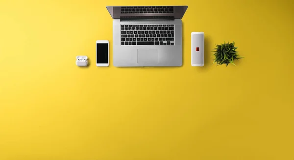 Byt ležel horní pohled kancelář pracovní prostor s notebookem na žlutém pozadí. Kopírovat prostor. — Stock fotografie