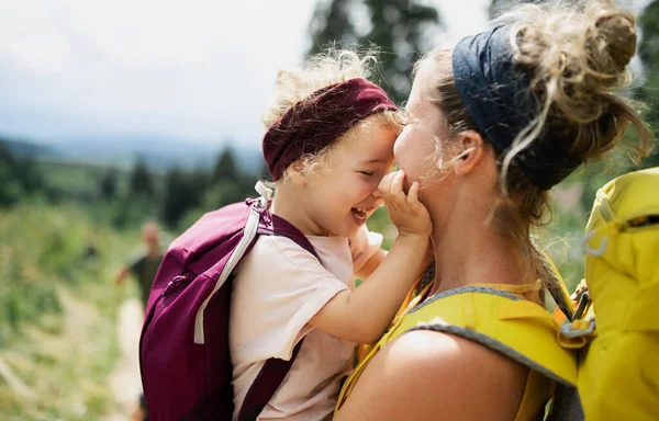 Мать с маленькой дочерью прогулки на открытом воздухе в летней природе, обниматься. — стоковое фото