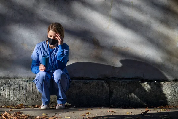 Orolig kvinnlig vårdgivare eller hälso- och sjukvårdspersonal som har ett genombrott utomhus, coronavirus koncept. — Stockfoto