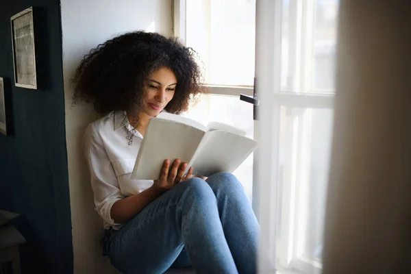 Портрет молодой женщины с книгой в помещении дома, чтение. — стоковое фото