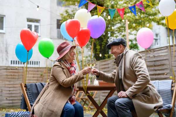 Szczęśliwa para seniorów z winem w kawiarni na świeżym powietrzu w mieście, świętowanie urodzin. — Zdjęcie stockowe