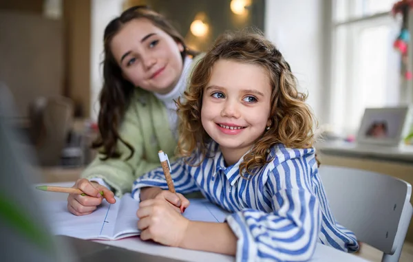 Zusters schoolmeisjes leren online binnen thuis, coronavirus concept. — Stockfoto