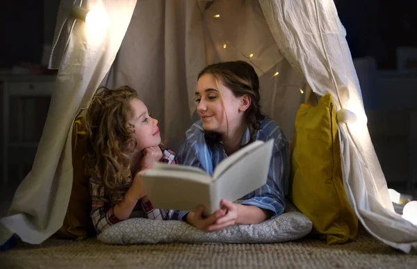 Schwestern zu Hause, Bücher lesen im Schlafanzug. Lockdown-Konzept. — Stockfoto