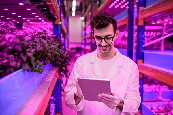 Worker with tablet on aquaponic farm, sustainable business and artificial lighting. — Stock Photo, Image
