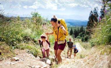Küçük çocuklu bir aile yazın doğa yürüyüşü yapıyor, High Tatras 'ta yürüyor..