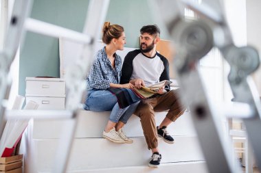 Evde renk örnekleri olan orta yaşlı çiftler, taşınma ve sönme konsepti..