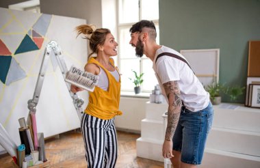 Çift evde duvar boyarken eğleniyor, yer değiştiriyor ve konsept değiştiriyor..