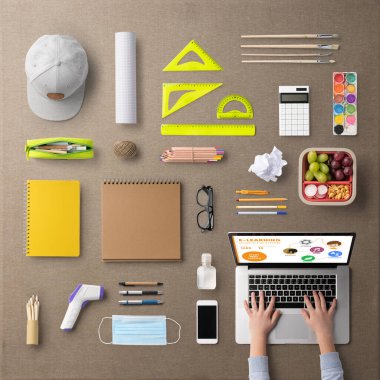 Okul malzemeleri, uzaklık öğrenimi ve koronavirüs kavramına düz bir görünüm sergiliyordu.