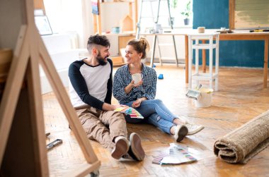 Evde renk örnekleri olan orta yaşlı çiftler, taşınma ve sönme konsepti..