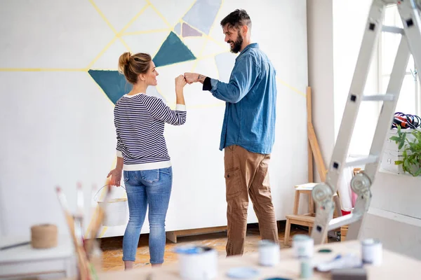 Çift evde duvar boyarken eğleniyor, yer değiştiriyor ve konsept değiştiriyor..