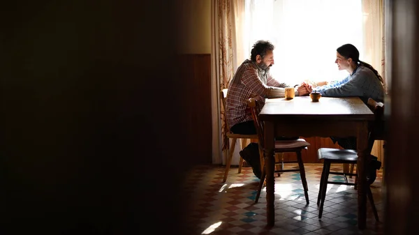 Retrato de pobre casal maduro conversando dentro de casa, conceito de pobreza. — Fotografia de Stock