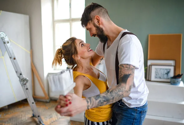 Couple having fun when painting wall indoors at home, relocation and diy concept. — Stock Photo, Image