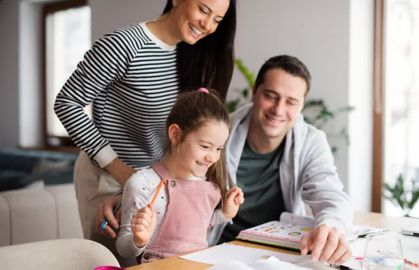 Parents with school girl indoors at home, distance learning and home office.