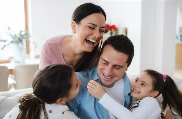Vrolijke ouders met kleine dochters binnen thuis, plezier hebben. — Stockfoto