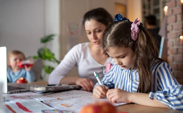 Anne ve küçük kızı mutfakta, evde eğitim ve uzaktan öğrenme konsepti. — Stok fotoğraf
