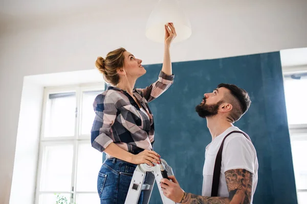 Midden volwassenen koppelen verschonen gloeilamp binnen thuis, verhuizing en diy concept. — Stockfoto