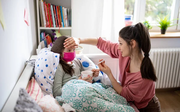 Mutter pflegt kranke kleine Tochter zu Hause im Bett, Coronavirus-Konzept. — Stockfoto