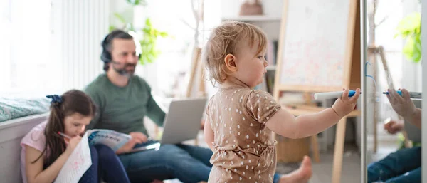 Vater arbeitet mit kleinen Töchtern im Schlafzimmer, Home Office Konzept. — Stockfoto