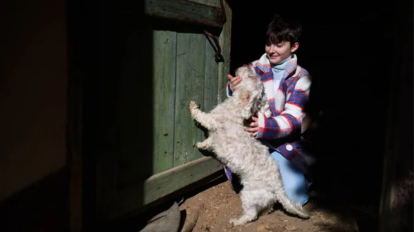 Armes kleines Mädchen, das draußen vor dem Haus mit Hund spielt, Armutskonzept. — Stockfoto