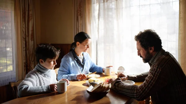 Retrato de pobre menina triste com os pais comendo dentro de casa, conceito de pobreza. — Fotografia de Stock