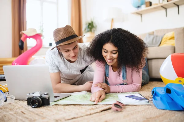 Young couple with laptop packing for holiday at home. — Stock Photo, Image