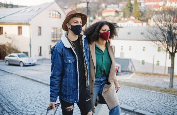 Молодая пара туристов с багажом ходить по улицам в старом городе, коронавирусная концепция. — стоковое фото