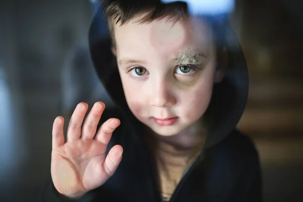 Poor sad small boy with cut eyebrow standing indoors at home, poverty concept. — Stock Photo, Image