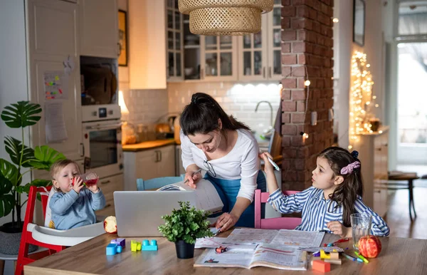 Moeder met kleine dochter in keuken, thuisonderwijs, kantoor en afstandsonderwijs concept. — Stockfoto