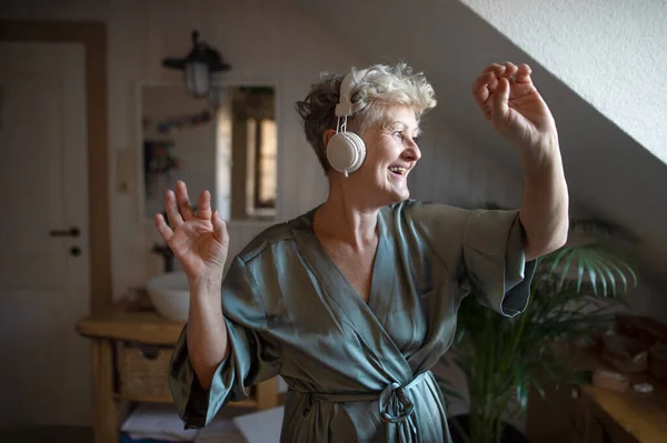 Happy senior woman with headphones dancing at home, relax and self-care concept. — Stock Photo, Image