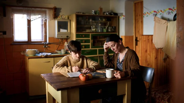 貧しい成熟した母親と小さな娘は自宅で屋内で学びます,貧困コンセプト. — ストック写真