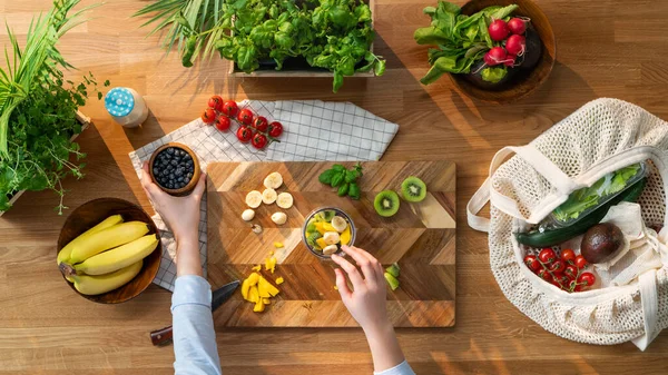 Vista superior de la mujer irreconocible preparando batido de frutas, estilo de vida sostenible. —  Fotos de Stock